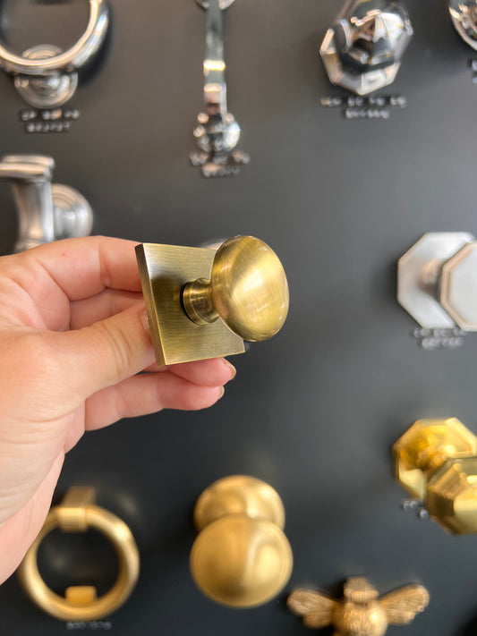 Victorian round cabinet knob with square backplate in antique brass